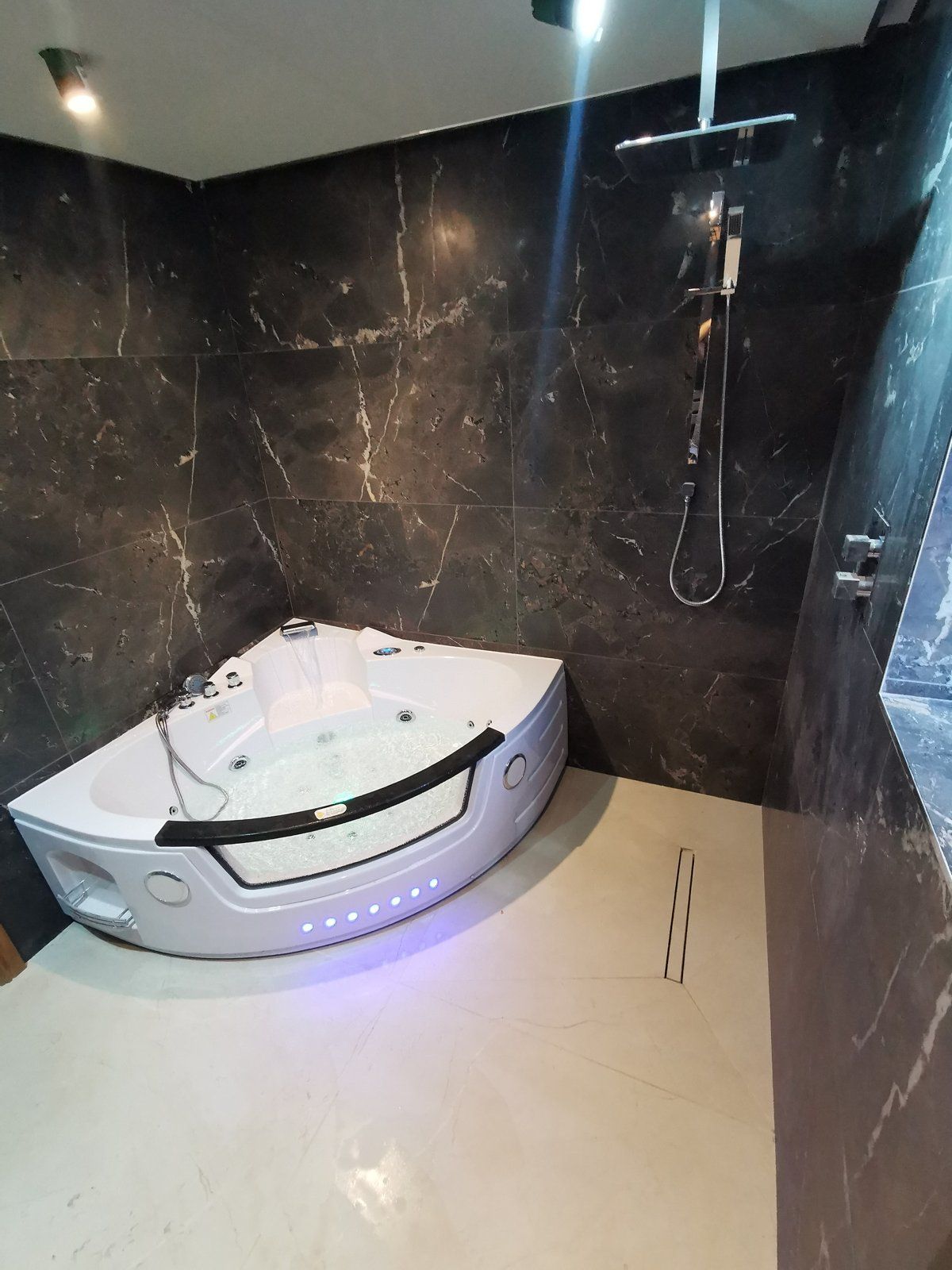 Black marble bathroom with corner spa bath - main photo