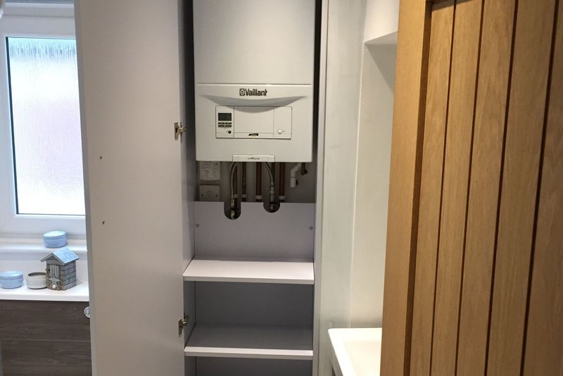 Wall-mounted gas boiler neatly installed in a utility cupboard